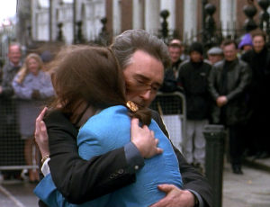 John and Jennifer hug outside the embassy.