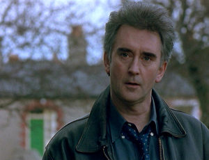 John, in park, wearing leather jacket.