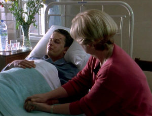 Harriet sits at Nate's bedside