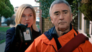 Steve in a high-vis vest, Sandra displaying her police warrant card behind him